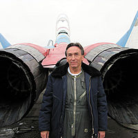 Abe wore a pressure suit for his flight to the edge of space. Here, he stands behind the MiG-29.