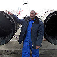 Robert stands behind the MiG-29 that carried him to the edge of space.